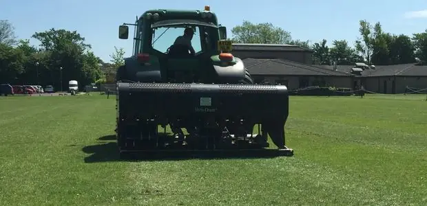Tractor-mounted Verti-Drain aerating a sports field